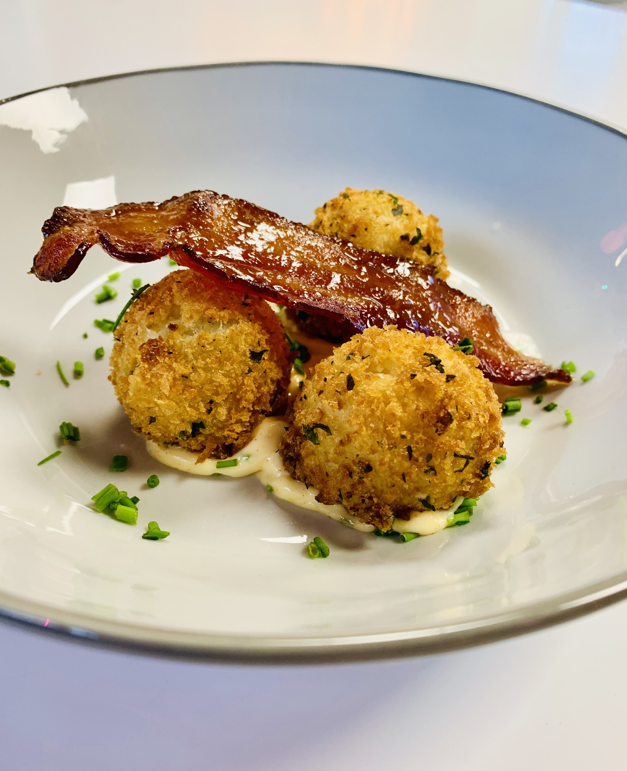 Potato Croquette topped with Chive Aioli and Maple Liqueur Candied Bacon
